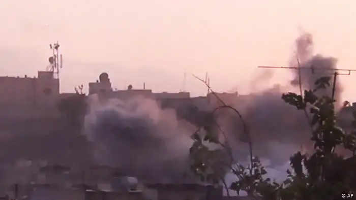 In this image made from amateur video released by the Shaam News Network and accessed Tuesday, June 26, 2012, smoke rises from buildings following purported shelling in Homs, Syria. (Foto:Shaam News Network via AP video/AP/dapd) TV OUT, THE ASSOCIATED PRESS CANNOT INDEPENDENTLY VERIFY THE CONTENT, DATE, LOCATION OR AUTHENTICITY OF THIS MATERIAL