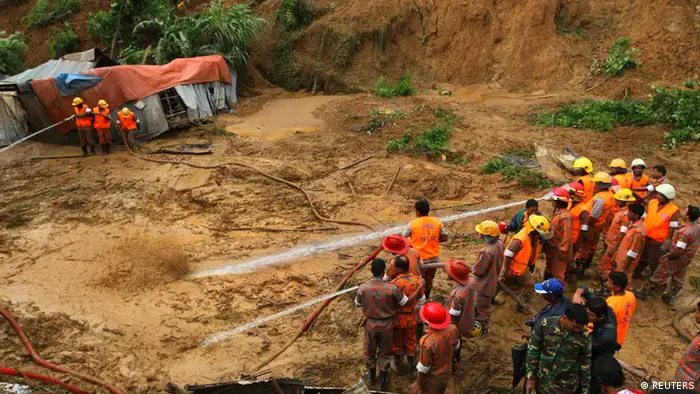 Fire fighters spray water to loosen the soil during a rescue operation following a landslide in Chittagong June 27, 2012. Days of rain in Bangladesh, some of the heaviest in years, have set off flash floods and landslides, killing at least 70 people and stranding about 200,000, police and officials said on Wednesday. REUTERS/Stringer (BANGLADESH - Tags: DISASTER)