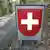 A white cross on a red background sign at the Swiss border