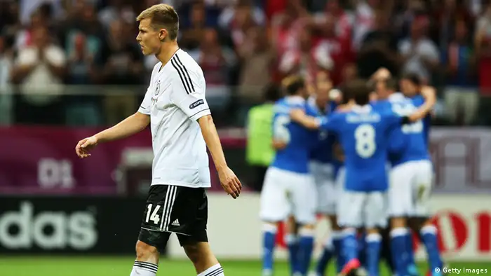 WARSAW, POLAND - JUNE 28: Holger Badstuber of Germany shows his dejection as Italy plaayers celebrate scoring the opening goal during the UEFA EURO 2012 semi final match between Germany and Italy at National Stadium on June 28, 2012 in Warsaw, Poland. (Photo by Alex Grimm/Getty Images)