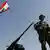 A Lebanese soldier stands next to a Lebanese flag on top of an armoured personnel carrier at a checkpoint in the southern border town of Kafarkila, Lebanon, Monday, Aug. 28, 2006.(ddp images/AP Photo/Karel Prinsloo)