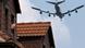 A man sticks his head out of the window of his brick home as a commercial aircraft flies over the rooftops Photo: Michael Probst A man sticks his head out of the window of his brick home as a commercial aircraft flies over the rooftops Photo: Michael Probst