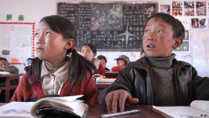 Chinese children listen to their teacher during a reading class in Yanmaidi village, in China's southwest Sichuan province, March 18, 2005. Children ranging in age from 7 to 12 years old all attend the same class with the school's only teacher. On the coldest days children bring buckets of smoldering coal to keep warm in the unheated classroom. (ddp images/AP Photo)