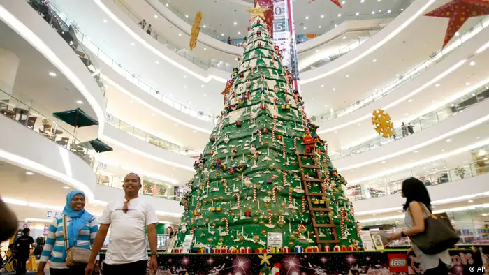 Shoppers walk past a 7-meter (23-foot) Christmas tree made of 850,000 LEGO bricks at Senayan City shopping mall in Jakarta, Indonesia, Monday, Dec. 14, 2009. (ddp images/AP Photo/Tatan Syuflana)