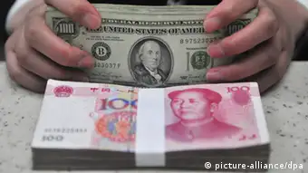 ARCHIV - Ein chinesischer Bankangestellter zählt US Dollar hinter einem Bündel chinesischer Banknoten in einer Bankfiliale der Huaxia Bank in Shenyang (Archivbild vom 14.01.2011). Die Inflation ist in China weiter gefallen. Der Rückgang auf den niedrigsten Stand seit 29 Monaten gibt der Regierung neuen Raum zur Ankurbelung der Konjunktur. Nach Angaben der Staatsmedien rief Regierungschef Jiabao angesichts des schwächeren Wirtschaftswachstums zu einer «aggressiveren» Feinabstimmung in der Geldpolitik auf. EPA/MARK (Zu dpa 0155 vom 09.07.2012) +++(c) dpa - Bildfunk+++