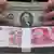 ARCHIV - Ein chinesischer Bankangestellter zählt US Dollar hinter einem Bündel chinesischer Banknoten in einer Bankfiliale der Huaxia Bank in Shenyang (Archivbild vom 14.01.2011). Die Inflation ist in China weiter gefallen. Der Rückgang auf den niedrigsten Stand seit 29 Monaten gibt der Regierung neuen Raum zur Ankurbelung der Konjunktur. Nach Angaben der Staatsmedien rief Regierungschef Jiabao angesichts des schwächeren Wirtschaftswachstums zu einer «aggressiveren» Feinabstimmung in der Geldpolitik auf. EPA/MARK (Zu dpa 0155 vom 09.07.2012) +++(c) dpa - Bildfunk+++