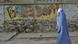 An Afghan woman clad in a burqa walks past a graffiti painted wall, in Herat, west of Kabul, Afghanistan on Thursday, May 13, 2010. (Photo: AP) An Afghan woman clad in a burqa walks past a graffiti painted wall, in Herat, west of Kabul, Afghanistan on Thursday, May 13, 2010. (Photo: AP)