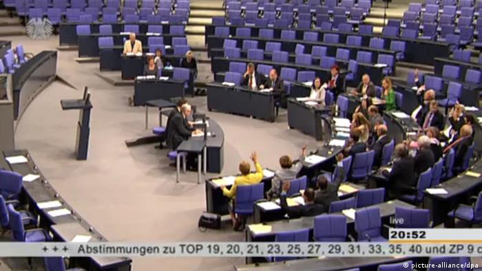 Wenige Abgeordnete stimmen im Bundestag mit Handzeichen ab (Foto: Deutscher Bundestag)