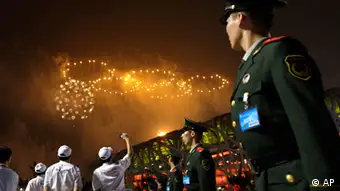 Police and volunteers watch the Olympic rings made from fireworks during the opening ceremony in the National Stadium at the Beijing 2008 Olympics in Beijing, Friday, Aug. 8, 2008. (AP Photo/Natacha Pisarenko)