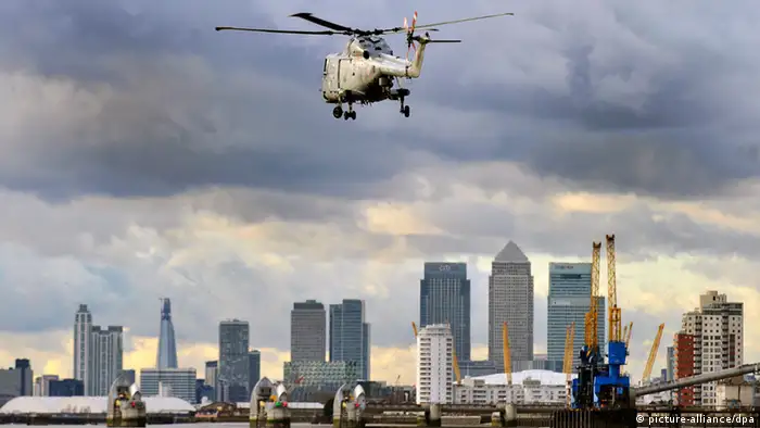 London 2012 ARCHIV - Ein britischer Navy-Helikopter fliegt bei einer Übung am 19.01.2012 über die Themse, im Hintergrund ist die Skyline von London zu sehen. London 2012 - die Themsemetropole will bei den Olympischen Spielen der Welt das Megaereignis schlechthin bieten. Sorgen um Sicherheit und Verkehrschaos trüben aber die Vorfreude auf den Start der Spiele. In einem halben Jahr wird das olympische Feuer entzündet. EPA/ANDY RAIN (zu dpa KORR: «London wappnet sich - die Uhr tickt für Olympia» vom 24.01.2012) +++(c) dpa - Bildfunk+++