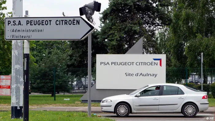 A car passes by signs of the PSA Peugeot Citroen plant in Aulnay-sous-Bois, north of Paris, in this photo dated Tuesday, June 19, 2012. French car maker PSA Peugeot Citroen unveils Thursday July, 12, 2012 cost-cutting measures that includes several thousand job-cuts. The maker of the popular Peugeot 207 hatchback is trying to save euro 1 billion ($1.2 billion) this year as it struggles to compete in Europe's fiercely competitive car market particularly amid a slump in sales in the recession-hit south of Europe.(Foto:Michel Euler/AP/dapd)