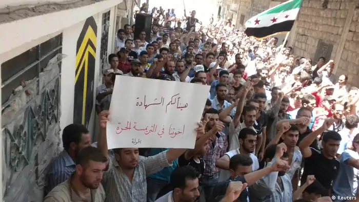Demonstrators protest against Syria's President Bashar al-Assad after Friday Prayers in Houla near Homs July 13, 2012. Placard read,Congratulations your martyrs, our brothers at al-Trimsa. Picture taken July 13, 2012. REUTERS/Shaam News Network/Handout (SYRIA - Tags: POLITICS CIVIL UNREST) FOR EDITORIAL USE ONLY. NOT FOR SALE FOR MARKETING OR ADVERTISING CAMPAIGNS. THIS IMAGE HAS BEEN SUPPLIED BY A THIRD PARTY. IT IS DISTRIBUTED, EXACTLY AS RECEIVED BY REUTERS, AS A SERVICE TO CLIENTS