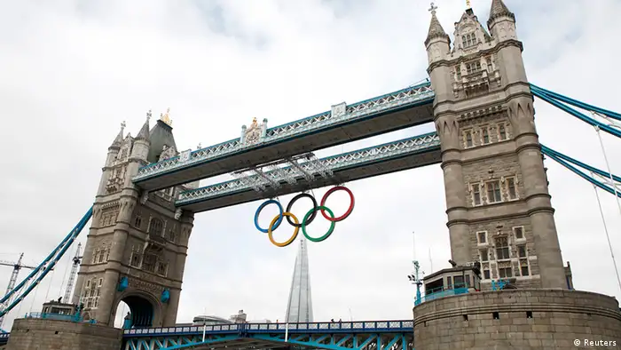 The Olympic Rings are seen hanging from Tower Bridge after being lowered into position for display from the walkways in central London, June 27, 2012. The London 2012 Olympic games will begin a month from today. REUTERS/Andrew Winning (BRITAIN - Tags: CITYSPACE SOCIETY SPORT OLYMPICS)