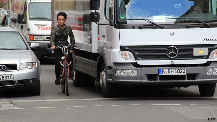 Fahrradfahrer zwischen Auto und Lastwagen (Foto: DW)