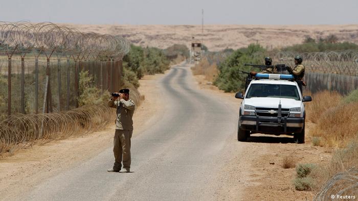 An Iraqi soldier looks through a pair of binoculars near the Iraqi-Syrian borders at the Abu Kamal-qaim border crossing, the main border post between Iraq and Syria, July 20, 2012. REUTERS/Saad Shalash
