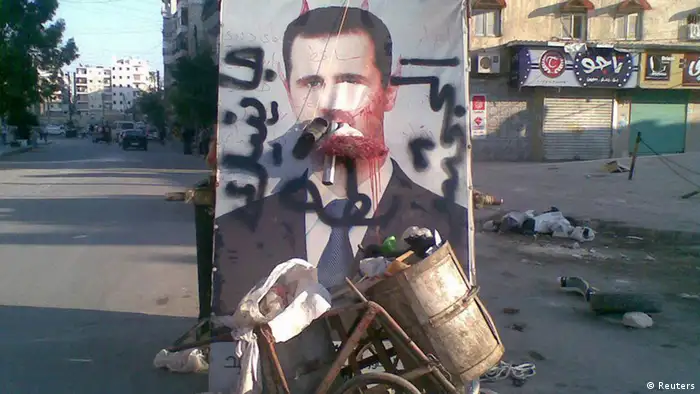 Source News Feed: EMEA Picture Service ,Germany Picture Service A defaced poster of Syria's President Bashar al-Assad is seen near garbage containers in Aleppo July 24, 2012. The words on the poster read, We coming, duck ass. Picture taken July 24, 2012. REUTERS/Shaam News Network/Handout (SYRIA - Tags: POLITICS CIVIL UNREST) FOR EDITORIAL USE ONLY. NOT FOR SALE FOR MARKETING OR ADVERTISING CAMPAIGNS. THIS IMAGE HAS BEEN SUPPLIED BY A THIRD PARTY. IT IS DISTRIBUTED, EXACTLY AS RECEIVED BY REUTERS, AS A SERVICE TO CLIENTS