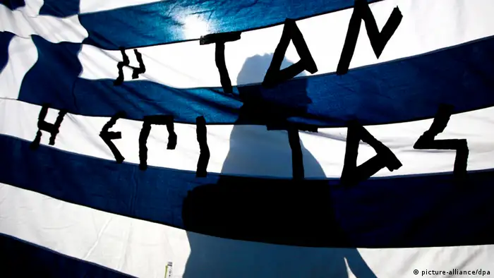 FILE - A protester walks behind a Greek flag that reads the ancient Spartan saying 'Either with it, or on it' during a general strike demonstration, outside the Greek Parliament in Athens, Greece, 20 October 2011. EPA/ALKIS KONSTANTINIDIS (zu dpa 0567 Griechenland droht Staatsbankrott - Märkte in heller Aufregung am 23.07.2012) +++(c) dpa - Bildfunk+++ pixel Schlagworte