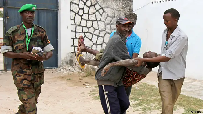 Somali police men carry an injured Somali soldier in Mogadishu Wednesday Aug.1, 2012 . The soldier was injured after two suicide bombers who were trying to blow up the constituent assembly venue were shot dead by security forces police said.(Foto:Farah Abdi Warsameh/AP/dapd)