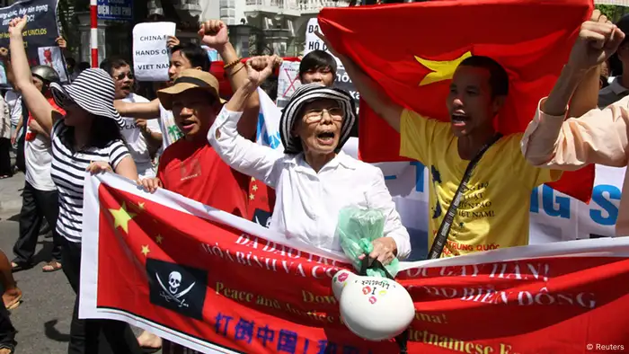 Protesters hold banners while chanting slogans during an anti-China protest along a street in Hanoi July 22, 2012. Some hundred Vietnamese demonstrated in Hanoi on Sunday against China's moves to strengthen its claim on disputed islands in the South China Sea and its invitation to oil firms to bid for blocks in offshore areas that Vietnam claims as its territory. Hanoi has also denounced a move by China to change the administrative status of Sansha City as a way of enforcing its claims to several largely uninhabited islands, including the Paracels and Spratlys. REUTERS/Nguyen Lan Thang (VIETNAM - Tags: POLITICS CIVIL UNREST)