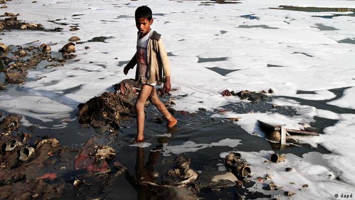 An Indian boy looks for reusable material in the polluted waters (photo:Tsering Topgyal/AP/dapd)
