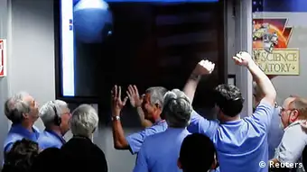 Source News Feed: EMEA Picture Service ,Germany Picture Service Image shot off a video screen from NASA TV shows members of the Mars Science Laboratory (MSL) team celebrating inside the Spaceflight Operations Facility for NASA's Mars Science Laboratory Curiosity rover at Jet Propulsion Laboratory after receiving the first few images from the Curiosity rover, in Pasadena, California August 5, 2012. Mission controllers at the Jet Propulsion Laboratory said they received signals relayed by a Martian orbiter confirming that the rover had survived a make-or-break descent and landing attempt to touch down as planned inside a vast impact crater. One of the first images sent from the rover is shown on screen in the background. REUTERS/Courtesy NASA TV/Handout (UNITED STATES - Tags: SCIENCE TECHNOLOGY) FOR EDITORIAL USE ONLY. NOT FOR SALE FOR MARKETING OR ADVERTISING CAMPAIGNS. THIS IMAGE HAS BEEN SUPPLIED BY A THIRD PARTY. IT IS DISTRIBUTED, EXACTLY AS RECEIVED BY REUTERS, AS A SERVICE TO CLIENTS