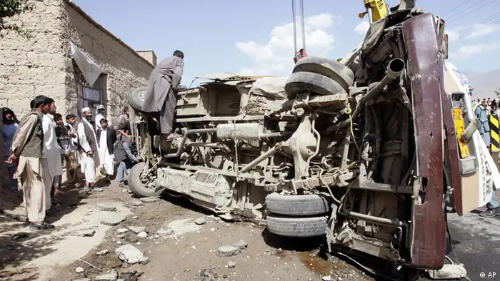 Afghans stand near a bus which was hit by a remote control bomb on the outskirts of Kabul, Afghanistan, Tuesday, Aug. 7, 2012. A militant detonated a remote-control bomb Tuesday morning, killing at least eight Afghan civilians who were traveling in a bus just northwest of the Afghan capital, police said. (Foto:Ahmad Nazar/AP/dapd).