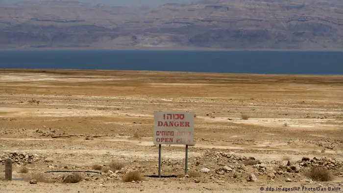 In this photo taken Thursday, May 28, 2009, a warning sign is seen near the Dead Sea coast. Geologist Eli Raz says the sinkholes phenomenon, underground craters that can burrow to the surface in an instant, sucking in whatever lies above, stems from a dire water shortage, compounded in recent years by a growing population and robust tourism and chemical industries. (ddp images/AP Photo/Dan Balilty) German industrial conglomerate Siemens AG said Monday June 22, 2009 that it expects to garner some 15 billion euro (US$20.9 billion) worldwide in new orders because of more government-backed mandates aimed at reducing energy consumption