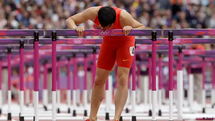 China's Liu Xiang kisses his hurdle after falling in a men's 110-meter hurdles heat during the athletics in the Olympic Stadium at the 2012 Summer Olympics, London, Tuesday, Aug. 7, 2012. (Foto:Anja Niedringhaus/AP/dapd)