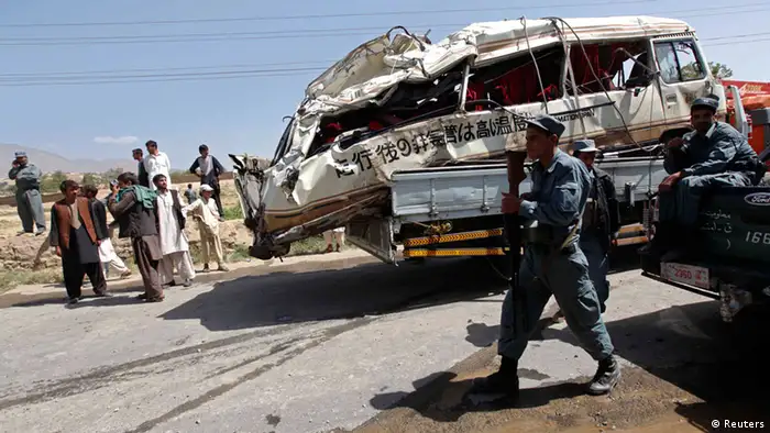 Afghan policemen walk next to a truck carrying the wreckage of a civilian bus that was hit by a remote-controlled bomb, in the Paghman district of Kabul August 7, 2012. A remote-controlled bomb hit a civilian passenger bus on Tuesday killing nine civilians and wounding three others, according to the district police chief. REUTERS/Omar Sobhani (AFGHANISTAN - Tags: CIVIL UNREST TRANSPORT CRIME LAW)