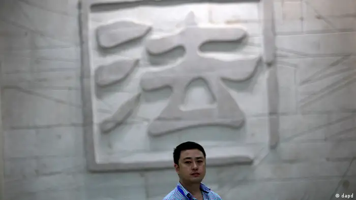 A man walks in front of the engraved wall depicting a Chinese character that means law inside the Hefei City Intermediate People's Court where a murder trial of Gu Kailai, wife of disgraced Chinese politician Bo Xilai, takes place Thursday Aug. 9, 2012 in Hefei, Anhui Province, China. The court heard in the one-day trial that Gu got British businessman Neil Heywood drunk and fed poison to him. (Foto:Eugene Hoshiko/AP/dapd)