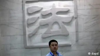 A man walks in front of the engraved wall depicting a Chinese character that means law inside the Hefei City Intermediate People's Court where a murder trial of Gu Kailai, wife of disgraced Chinese politician Bo Xilai, takes place Thursday Aug. 9, 2012 in Hefei, Anhui Province, China. The court heard in the one-day trial that Gu got British businessman Neil Heywood drunk and fed poison to him. (Foto:Eugene Hoshiko/AP/dapd)
