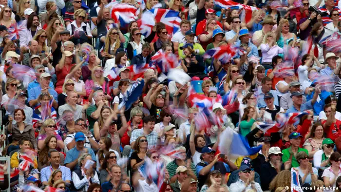 epa03345885 A slow exposure shows British fans cheer with Union Jack flags the Great Britain team after they won the gold medal in the Equestrian Team Jumping event for the London 2012 Olympic Games Equestrian Jumping competition in Greenwich Park, south east London, Britain, 06 August 2012. EPA/JIM HOLLANDER +++(c) dpa - Bildfunk+++