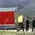 NATHU LA PASS, INDIA: A group of Chinese army officers walk past a display board on the Chinese part of the Indo-Chinese border of Nathu La, some 52 kilometres (33 miles) east of Gangtok, 05 July 2006. Formal trading is due to begin at the 15,000-foot (4,545 metre) Nathu La Pass on the border between India's Sikkim state and China's Tibet region, 06 July 2006. Indian businessmen and local people expect a change in the region's economy patterns following the formal resumption of trade between India and China when the Nathu La Pass, along the historic Silk Route, re-opens on the border. AFP PHOTO/ Deshakalyan CHOWDHURY (Photo credit should read DESHAKALYAN CHOWDHURY/AFP/Getty Images)