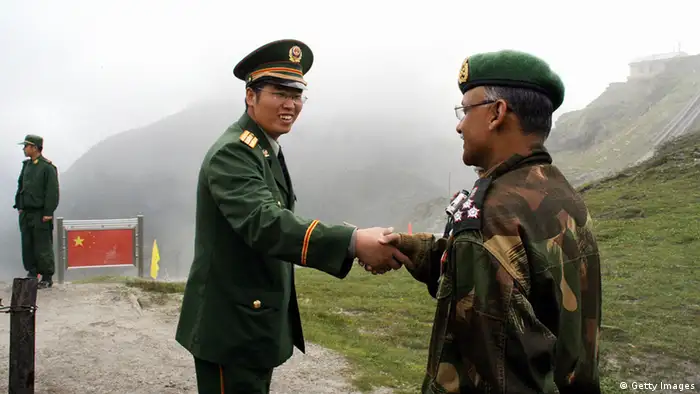 NATHU LA PASS, INDIA: A Chinese army officer (L) exchanges greetings with his Indian counterpart following a meeting among the officers, as they stand on the border of Nathu La, some 52 kilometres (33 miles) east of Gangtok, 05 July 2006. Formal trading is due to begin at the 15,000-foot (4,545 metre) Nathu La Pass on the border between India's Sikkim state and China's Tibet region. Indian businessmen and local people expect a change in the region's economy patterns following the formal resumption of trade between India and China when the Nathu La Pass, along the historic Silk Route, re-opens. AFP PHOTO/ STR (Photo credit should read STRDEL/AFP/Getty Images)