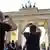 Tourists take photos of the Brandenburg Gate