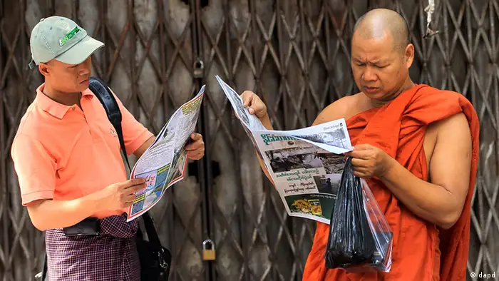 Myanmar man and Buddhist monk read a newspaper in Yangon, Myanmar Sunday, April 22, 2012. (Foto:Sakchai Lalit/AP/dapd)