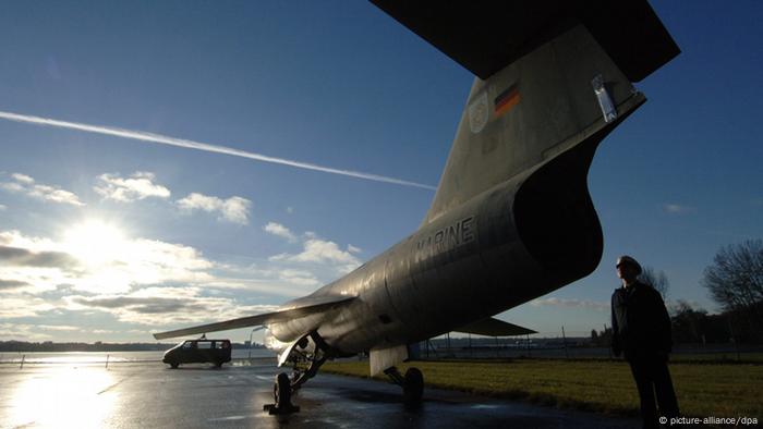 Ein Marinesoldat betrachtet einen Starfighter F-104 G im Gegenlicht auf dem Gelände des Marinestützpunktes in Kiel-Holtenau. (Bild: dpa)