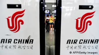 Passengers (C) check their boarding pass next to Air China counters at the Hongqiao airport in Shanghai on August 26, 2009. Air China, the nation's flag carrier, has said its net profit more than doubled in the first half of the year due to lower fuel prices, fuel hedging gains, and improving domestic travel demand. AFP PHOTO / PHILIPPE LOPEZ (Photo credit should read PHILIPPE LOPEZ/AFP/Getty Images)