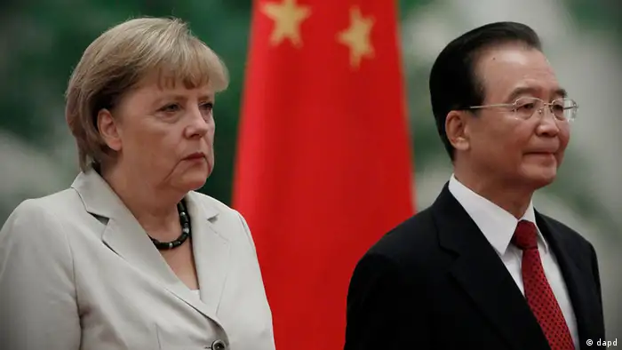 German Chancellor Angela Merkel, left, and Chinese Premier Wen Jiabao, right, stand near the Chinese national flag during a welcome ceremonyat the Great hall of the People in Beijing, Thursday, Aug. 30, 2012. (AP Photo/Ng Han Guan)