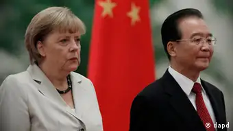 German Chancellor Angela Merkel, left, and Chinese Premier Wen Jiabao, right, stand near the Chinese national flag during a welcome ceremonyat the Great hall of the People in Beijing, Thursday, Aug. 30, 2012. (AP Photo/Ng Han Guan)