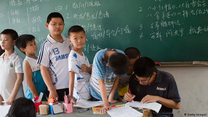 This picture taken on June 26, 2012, shows a group of children of migrant workers during classes at an illegal migrant school which has been ordered to close in Beijing, resulting in the children having to be sent back home to their provinces. Under China's complex residency laws, most migrant workers remain registered in their native towns or villages and do not qualify for the all-important hukou, or household registration permit, in the city where they live and without this document their children do not qualify for places in public schools, making the unregistered fee-paying migrant schools their only option. CHINA OUT AFP PHOTO (Photo credit should read STR/AFP/GettyImages) Quelle: Fars