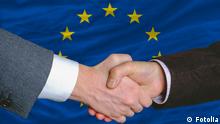 Lobbyismus Brüssel, Geschäftsmänner schütteln Hände vor Europaflagge