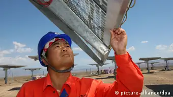 Chinese workers check and test solar panels at Fuguang photovoltaic power station in Hami city, northwest Chinas Xinjiang Uygur Autonomous Region, 6 August 2012. China, the biggest supplier of solar power panels, quadrupled a domestic installation goal for solar energy projects to 21 gigawatts by 2015 to help absorb the excess supply of panels and support prices. The target includes 1 gigawatt of solar-thermal power plants, said Shi Lishan, deputy director of the administrations renewable energy division. China had planned 5 gigawatts of capacity in the five years through 2015 and 20 gigawatts by 2020.