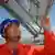 Ein chinesischer Arbeiter mit Helm prüft Solar-Paneele