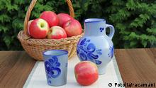 Eine Karaffe und ein Becher mit Apfelwein neben einem Korb mit Äpfeln stehen auf einem Tisch. Apfelwein © racamani #24063216 - Fotolia.com