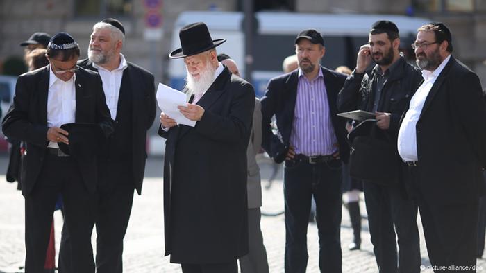 Der orthodoxe Rabbiner Yitzhak Ehrenberg (M) steht auf dem Bebelplatz in Berlin. (Foto: dpa)