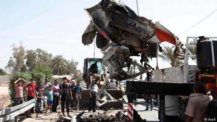 A destroyed car is moved from the scene of a car bomb attack in the town of Taji, about 12 miles (20 kilometers) north of Baghdad, Iraq, Sunday, Sept. 9, 2012. In violence, which struck at least 10 cities across the nation Insurgents killed at least 39 people in a wave of attacks against Iraqi security forces on Sunday, gunning down soldiers at an army post and bombing police recruits waiting in line to apply for jobs, officials said. (Foto:Karim Kadim/AP/dapd)