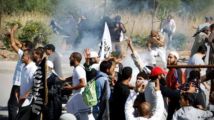 Protesters run for cover during a demonstration in front of the U.S. Embassy in Tunis September 14, 2012. At least five protesters were wounded when Tunisian police opened fire on Friday to quell an assault on the U.S. embassy compound in the capital Tunis, a Reuters reporter said. It was not immediately clear if police fired live rounds or rubber bullets. A large fire erupted inside the compound which has been invaded by hundreds of people incensed by a U.S.-made film that demeans the Prophet Mohammad. REUTERS/Zoubeir Souissi (TUNISIA - Tags: POLITICS RELIGION CIVIL UNREST)