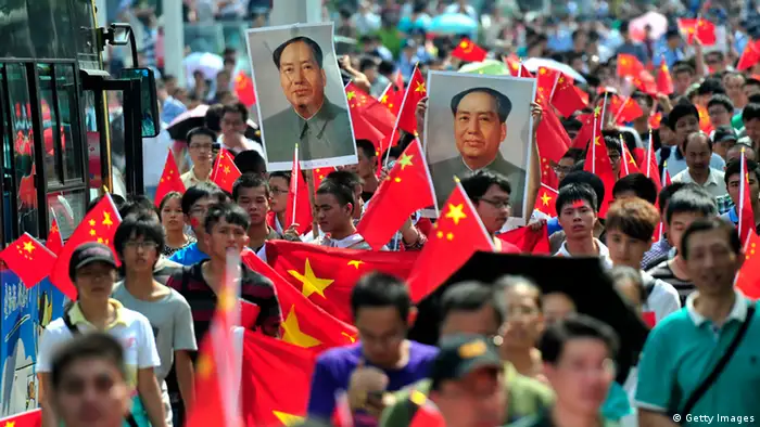 Chinese demonstrators carry national flags and portraits of Mao Zedong during a protest over the Diaoyu islands issue, known as the Senkaku islands in Japan, in Wuhan on September 16, 2012. Thousands of anti-Japanese demonstrators mounted protests in cities across China on September 16 over disputed islands in the East China Sea, a day after an attempt to storm Tokyo's embassy in the capital. CHINA OUT AFP PHOTO (Photo credit should read AFP/AFP/GettyImages)