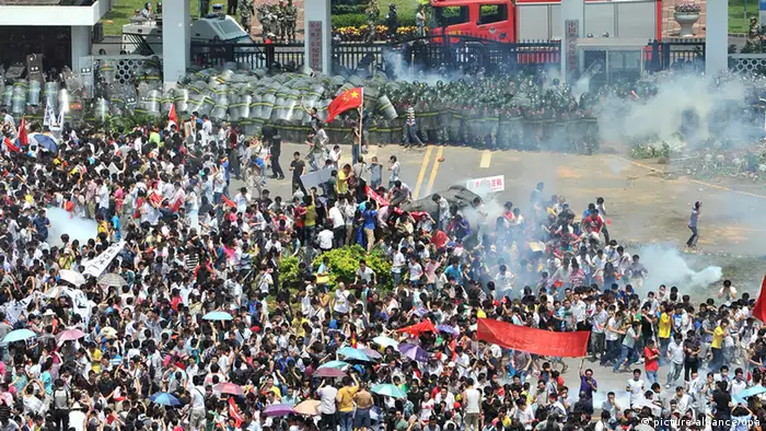epa03399644 Riot police fire tear gas at protesters outside the city headquarters of Communist Party of China during an anti-Japan protest in Shenzhen in south China's Guangdong province 16 September 2012. Protests across several Chinese cities continued, in the country's ongoing row with Japan over disputed islands in the South China Sea. In the capital, Beijing, several thousand people, mostly young, carried Chinese flags and images of Mao in front of the Japanese embassy. Police were seen in heavy numbers. The demonstrators called on Japan to withdraw from the islands. The dispute between the two countries escalated on Friday when six Chinese ships began patrolling the waters around the islands. EPA/LAN QING CHINA OUT